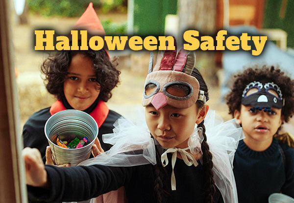 Halloween Safety. Three children are in dressed in Halloween costumes and are knocking on a door to trick-or-treat.