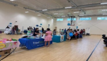 People visiting various tables at the Community Baby Shower.