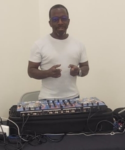Man standing behind a mixing sound board.