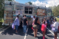 People are waiting in front of a food truck.