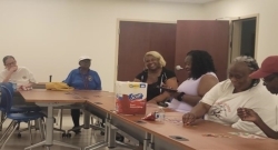 People playing Bingo at tables with assorted prizes.