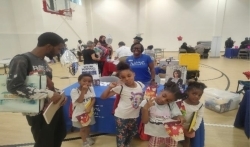 Residents got snacks and school supplies from various tables and people in an auditorium.