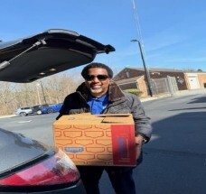 A man holding a box of food.