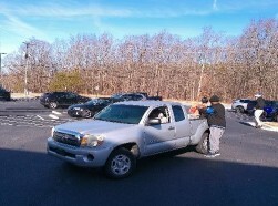 People standing around a pickup truck.