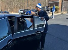 A man holding the door of a car open.