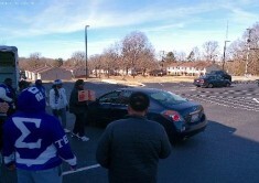 People standing around a car.