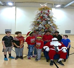 A group of kids standing around Santa.