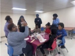 A group of people standing around a table.