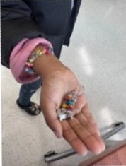 A hand holding a friendship bracelet.