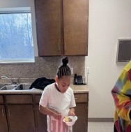 A girl holding a pink bowl.