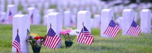 A cemetery with American flags by every headstone.