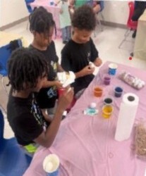 Three kids decorating eggs.
