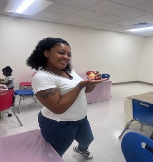 A girl holding a plate of colored eggs.