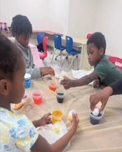 A group of kids decorating easter eggs.