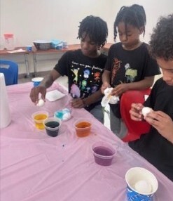 Three boys decorating easter eggs.
