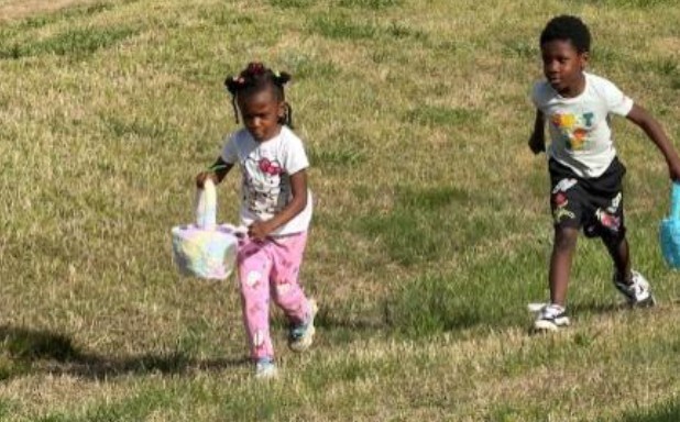 A young boy and girl collecting eggs in the easter egg hunt.