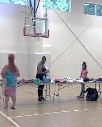 Three people look at clothes.
