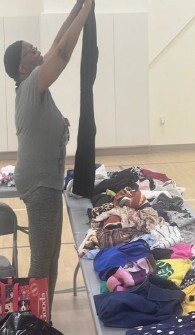 A woman holding up a pair of pants.