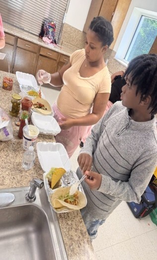 A woman and young boy making tacos.
