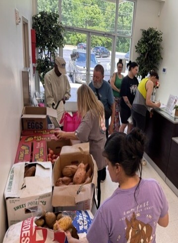 People looking in boxes of food.