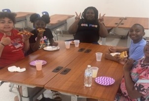 Five kids sitting around a table.