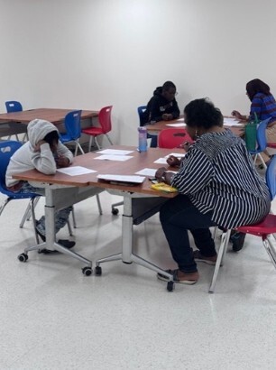 A group of kids sitting around a table.