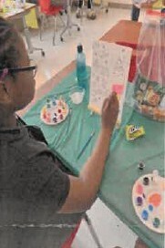 A girl painting at a table.