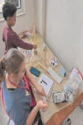Two people doing art on a table.