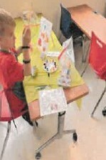 A young boy sitting at table.