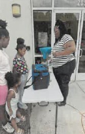 A woman talking to people at a table outside the door.