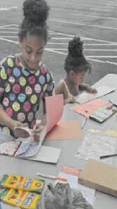 Two young girls coloring on a table.