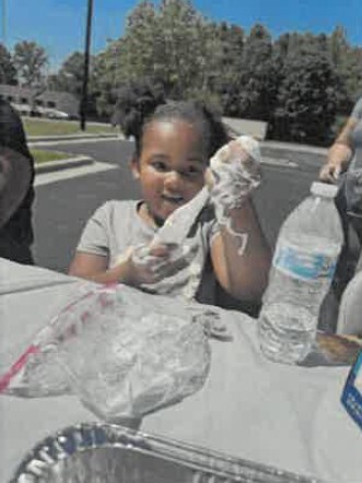 A girl playing with melted marshmallow.