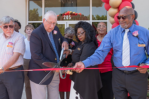 Lois Hunter and others holding large scissors at the Ribbon Cutting at Lois A Hunter Community Cener