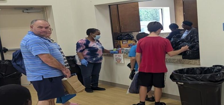 Some kids and some adults waiting to get supplies.