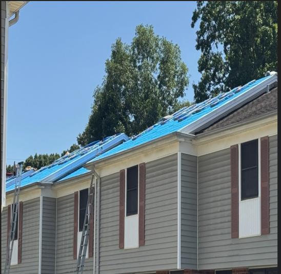 A close up of a James Avenue apartment building with roof work going on.