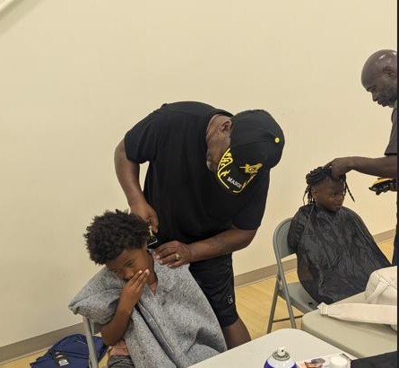 A barber giving a boy a haircut.