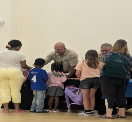 Kids and adults gathered around a table.